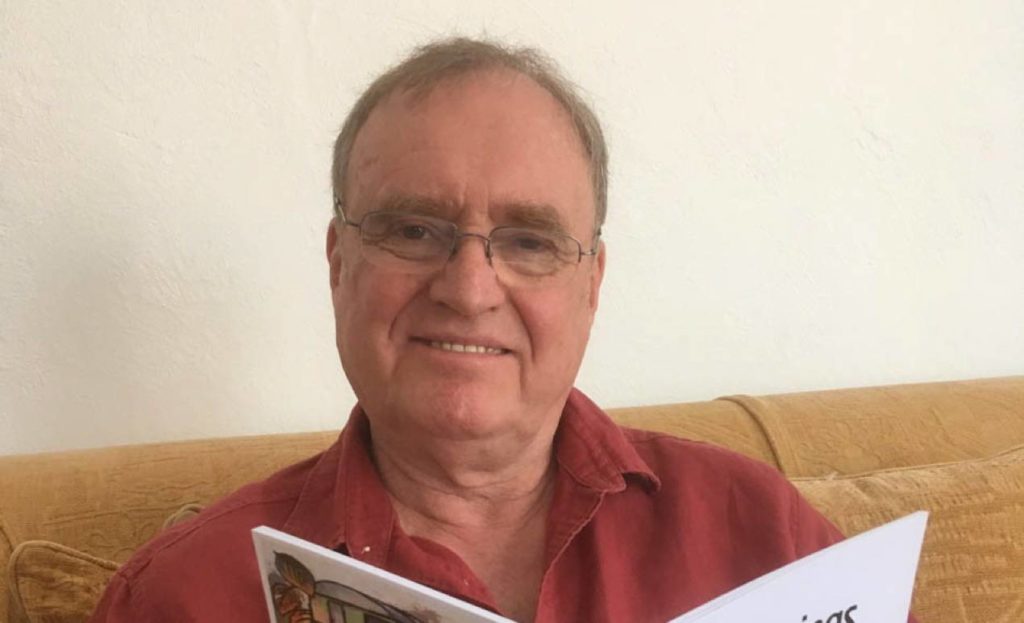 Trevor Hughes with his poetry collection which charts his relationship with his son Peter